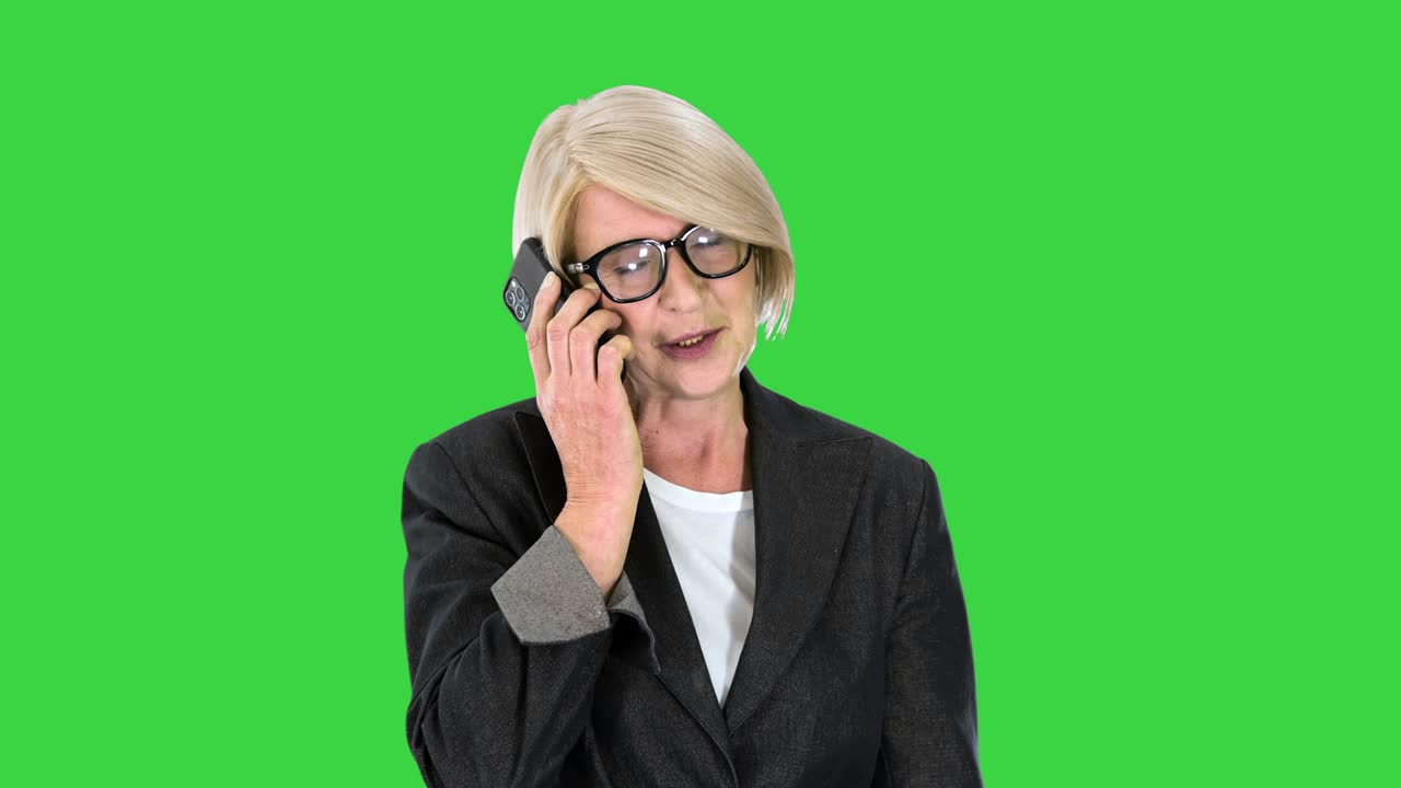 старшая бизнесменка делает звонок во время ходьбы по зеленому экрану, хроматический ключ