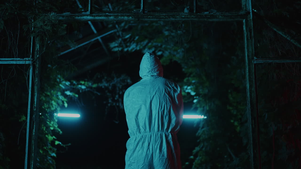 Mysterious Figure in Abandoned Greenhouse at Night