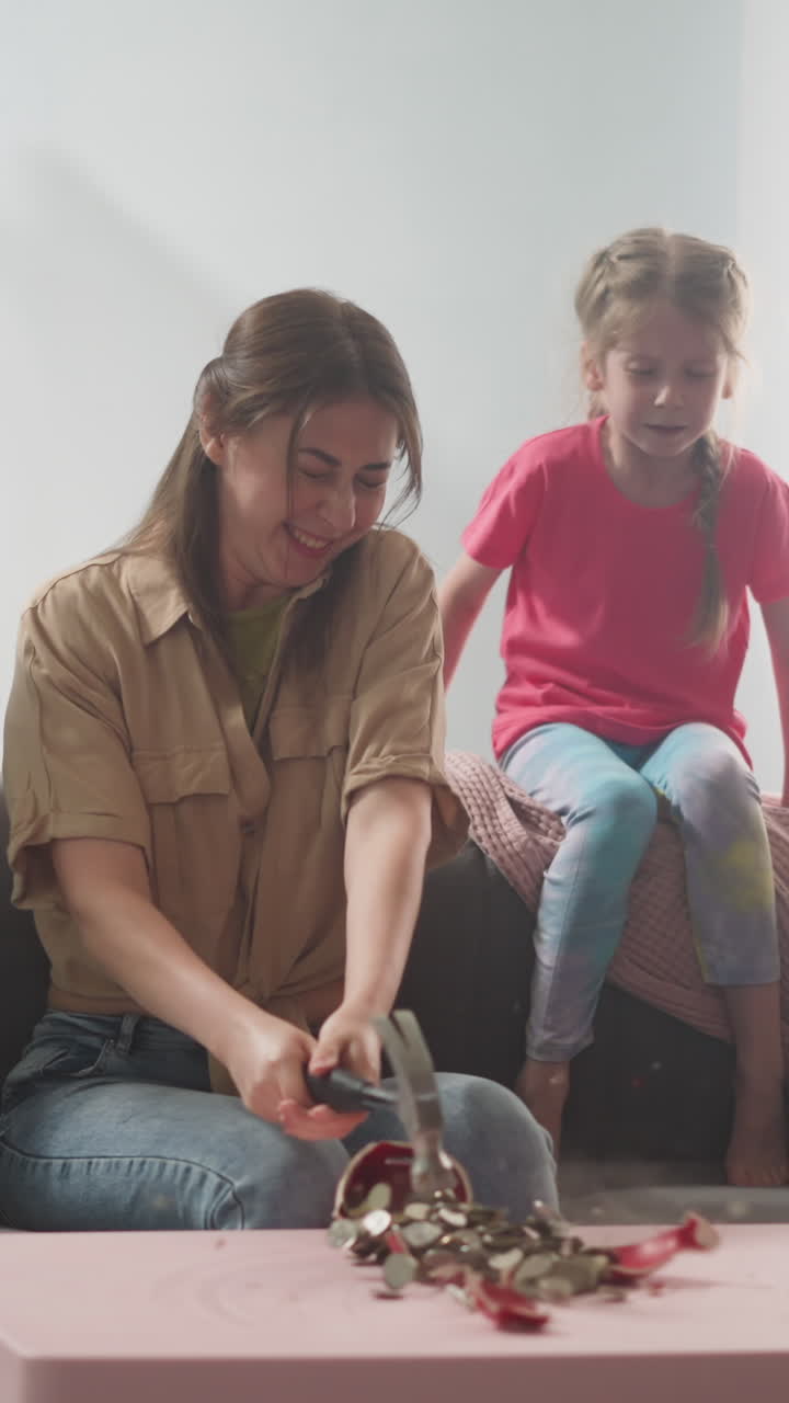 young mother with children breaks piggy bank with hammer with money in form of pig, money box doit
