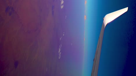 wide angle view of airplane wing flying over african desert