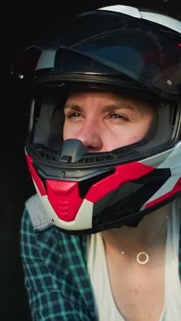 dos mujeres con cascos inclinadas hacia adelante, intensamente enfocadas en algo fuera de la pantalla, una está en un casco negro y la otra en un casca roja y blanca