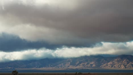 Cielo-Dramático-Sobre-La-Cordillera-Con-Tierra-Desértica-En-Primer-Plano,-Timelapse