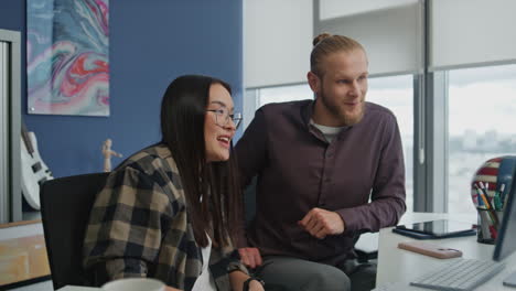 positive bloggers waving monitor at hipster flat. asian woman presenting herself
