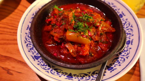 delicious spicy chakhokhbili georgian chicken stew with tomatoes and herbs at a restaurant, traditional cuisine, 4k shot