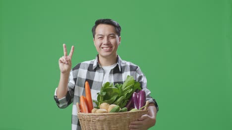 un agricultor feliz sosteniendo una canasta de verduras