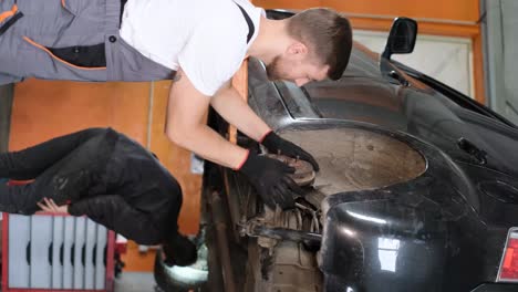 man working on a car in an auto repair shop
