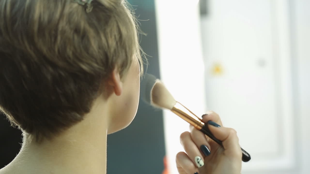 Woman having make up. Woman applying her make-up with big brush