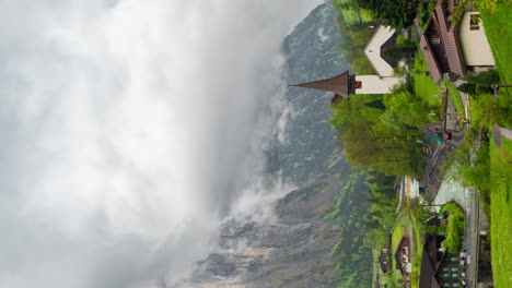 vertical 4k timelapse, lauterbrunnen village in swiss alps, homes and church under clouds and peaks