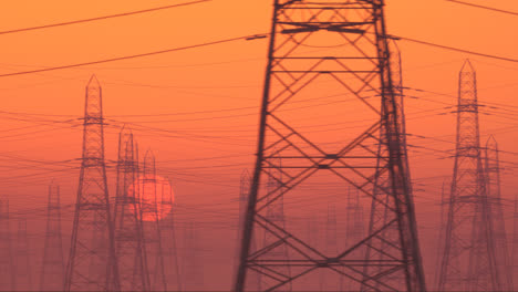 Seitwärts-Bewegte-Kamera-Blickt-Bei-Sonnenuntergang-Auf-Strommasten.-Dramatischer,-Roter-Himmel-Mit-Untergehender-Sonne-Und-Stromübertragungsleitungen.-Energieverteilungsnetz.-Endlosschleifenaufnahme-In-4K