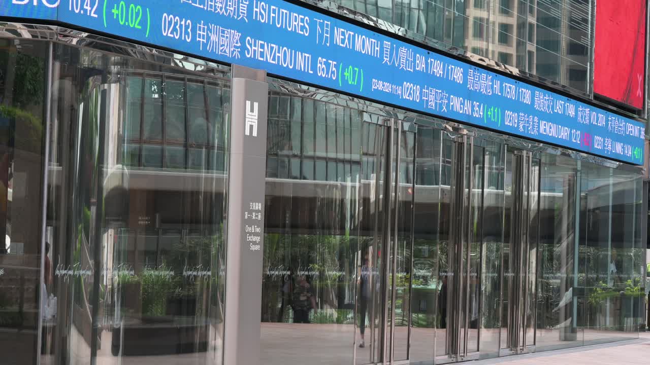 The Exchange Square building, home to the Hong Kong Stock Exchange (HKEX), as a moving screen displays stock ticker symbols in Hong Kong’s financial district.