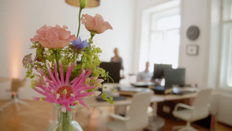 man and woman in office with flowers in the foreground