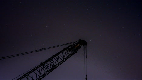 Una-Hermosa-Noche-Estrellada-Gira-Alrededor-De-La-Estrella-Del-Norte-Detrás-De-Una-Grúa-De-Construcción-En-Silueta