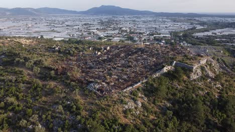 Un-Dron-Se-Acercaba-A-Las-Ruinas-De-Sillyon,-Una-Antigua-Fortaleza-Cerca-De-Attaleia-En-Panfilia,-Que-Muestra-Una-Ciudad-Moderna-En-La-Costa-Sur-De-Turquía.