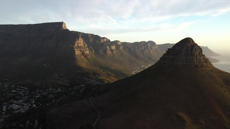 Ripresa cinematografica aerea discendente con gru del Parco Nazionale della Table Mountain di Città del Capo e della cima Lion's Head durante il tramonto all'ora d'oro