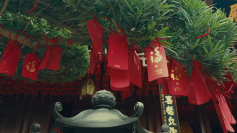 red tags of wishes hanging from a tree in a chinese temple