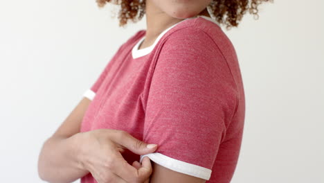 sección media de una mujer afroamericana con una camiseta roja con espacio de copia en fondo blanco.