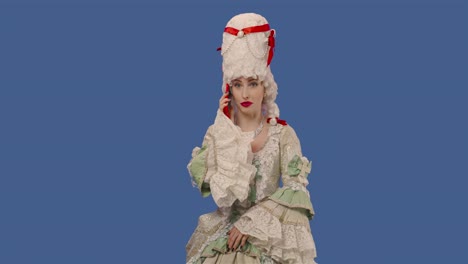 portrait of a courtier lady in a white vintage lace dress and wig talking on her smartphone. young woman posing in studio with blue screen background. close up. slow motion ready 59.94fps