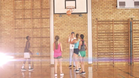 animation of light spots over diverse schoolchildren playing basketball at gym