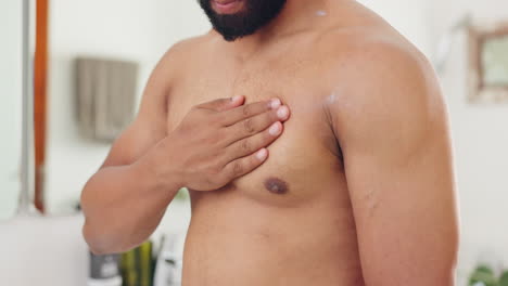 man applying lotion to his shoulder and chest