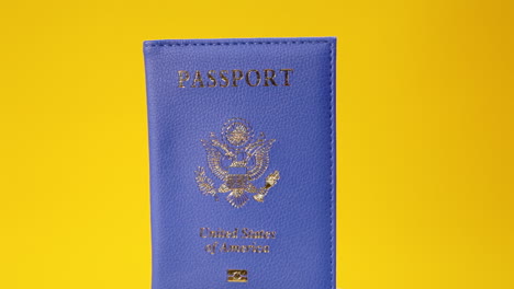 Un-Pasaporte-Azul,-Con-El-Emblema-Y-El-Texto-Estados-Unidos-De-América,-Sobre-Una-Superficie-Giratoria