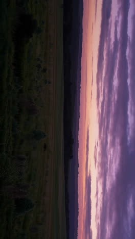 sunset over a field and hills