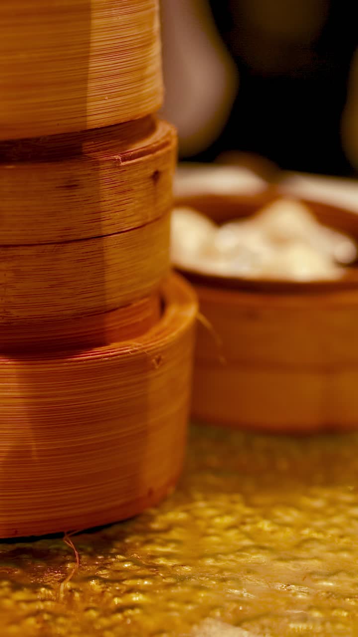 Kukusan bambu menampilkan dim sum lezat dalam suasana yang hangat dan mengundang. Tangkapan dekat mengabadikan esensi masakan Tiongkok tradisional.