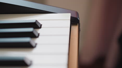 child hand presses power button on electronic piano