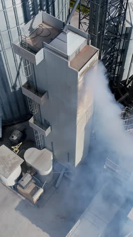 aerial view of a grain processing facility with a drying tower and silos