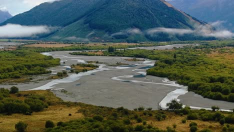 vías fluviales curvas y serpenteantes que atraviesan tierras bajas con nubes bajas a lo largo de bosques de haya, glenorchy