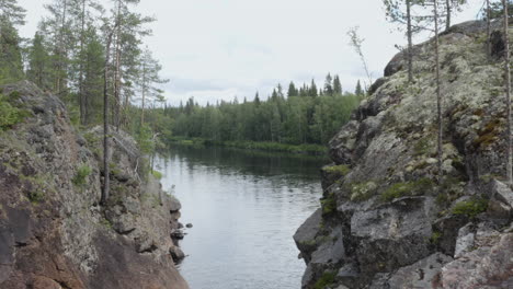 4k-Drone-flying-close-to-steep-mountain-cliffs-near-a-beautiful-lake-in-the-woods