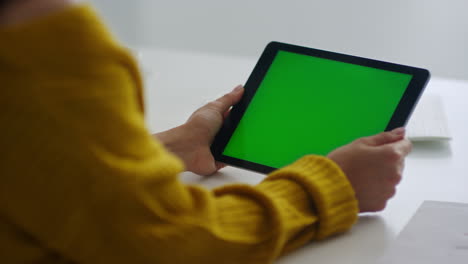 mujer con las manos sujetando una tableta con pantalla verde. niña leyendo una carta en la celda de remos