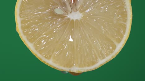 con una rebanada redonda de limón cayendo gota de jugo.
