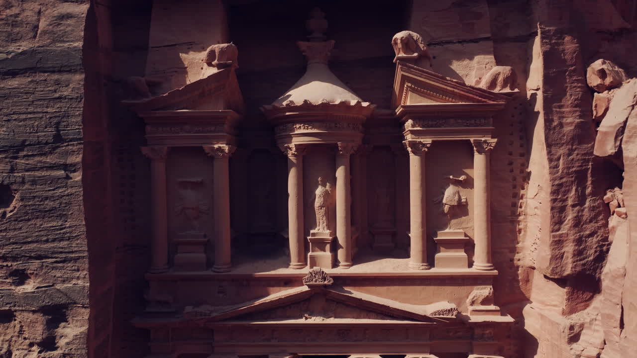 Il Tesoro (Al-Khazneh), antica tomba, architettura della facciata scolpita nella roccia, Petra, ripresa aerea ascendente.