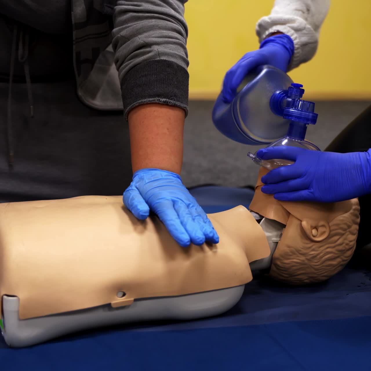 Training on a medical mannequin. People doing cardiopulmonary resuscitation. Procedure of chest compression on a dummy.