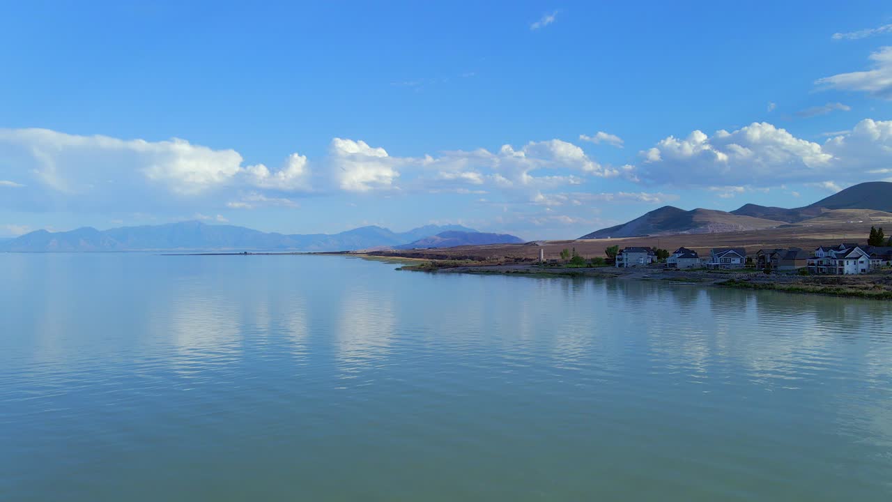 съемка с дрона с фиксированным изображением красиво спокойной ряби на озере юта движется к берегу с горным хребтом позади