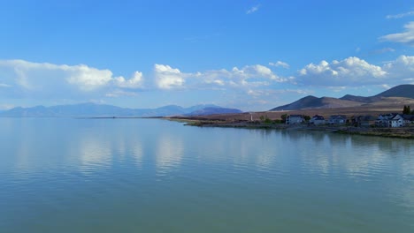 disparo de dron fijo de ondas bellamente tranquilas a través del lago de utah que se mueven hacia la orilla con una cadena montañosa detrás