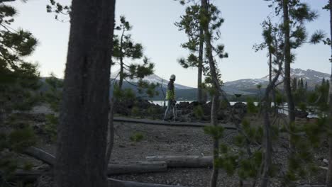 Man-Walking-besides-scenic-lake-as-camera-follows-along