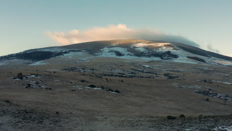 Vista-Aérea-De-La-Cima-De-La-Montaña-Con-Niebla-Pasando-Rápidamente-Sobre-La-Cumbre