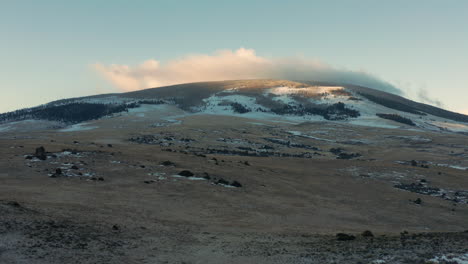 Aerial-view-of-mountaintop-with-fog-quickly-passing-over-summit