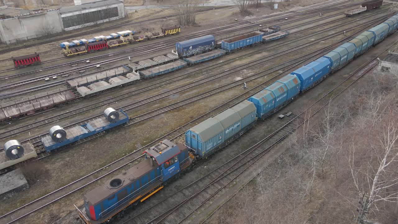 산업 지역 옆에서 기차 속도가 느려지는 항공 보기 - 기차와 함께 비행