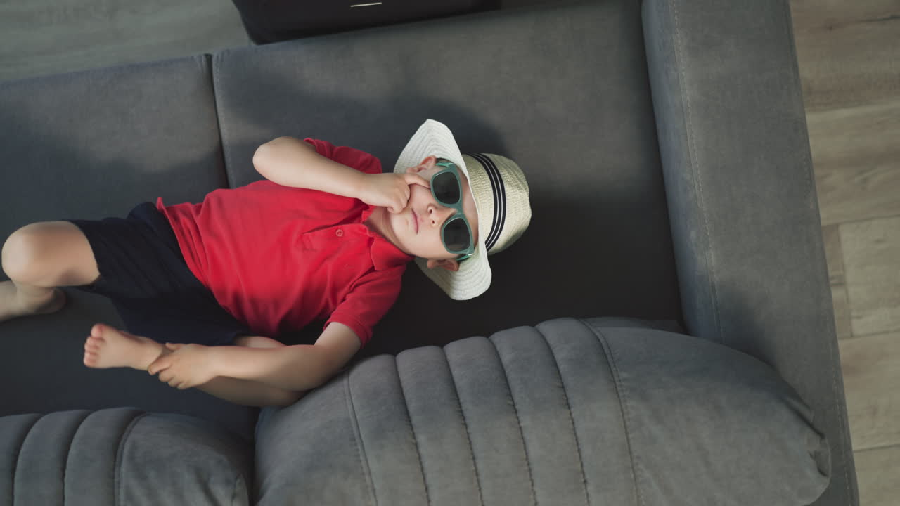 un niño pequeño y elegante se acuesta en un cómodo sofá en una suite de hotel