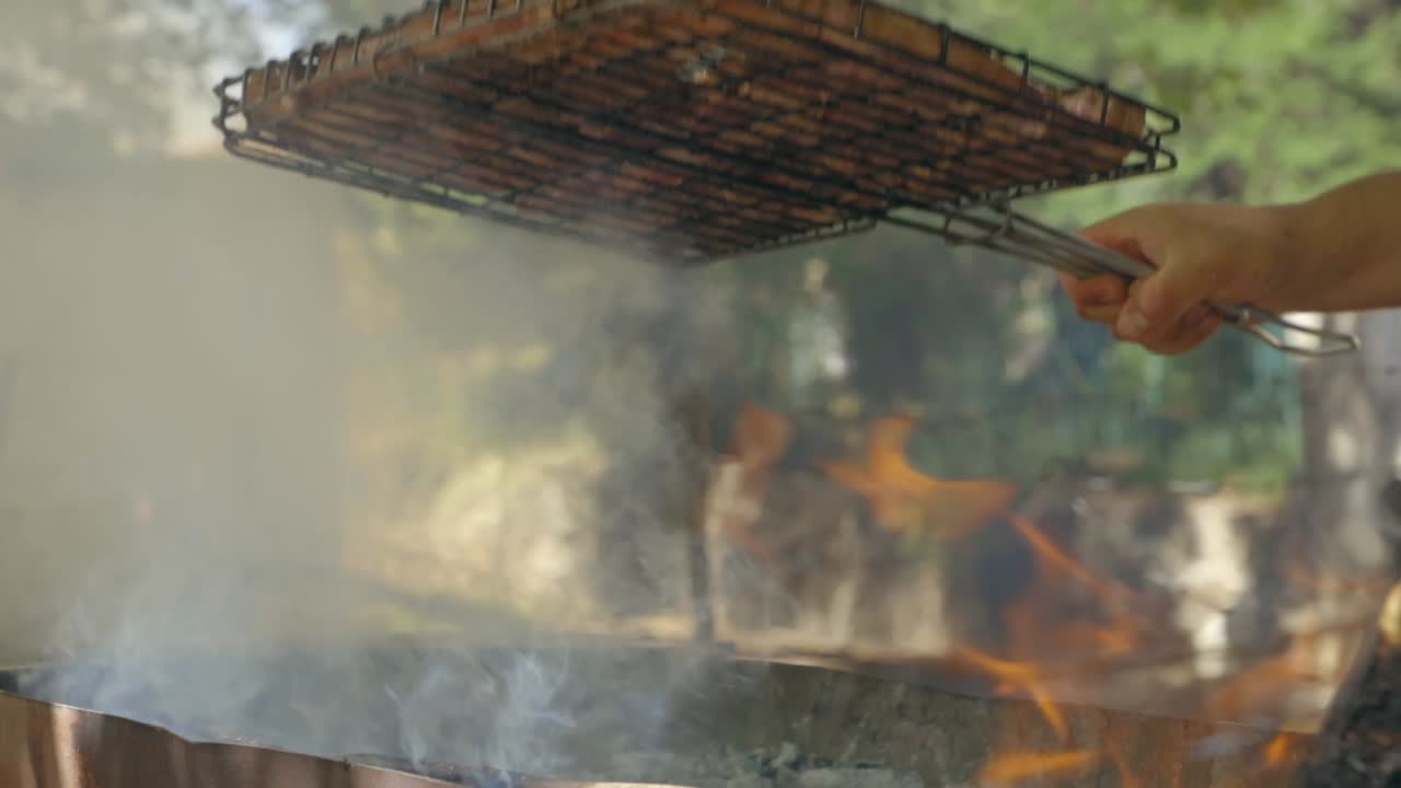 60fps로 바비큐에서 고기를 돌리는 슬로우 모션 남자