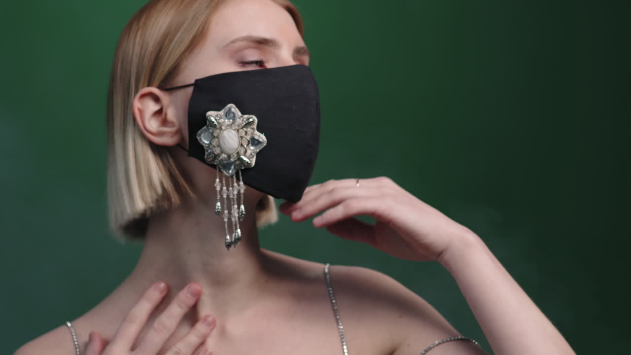 우아한 드레스와 얼굴 마스크를 입은 아름다운 여성