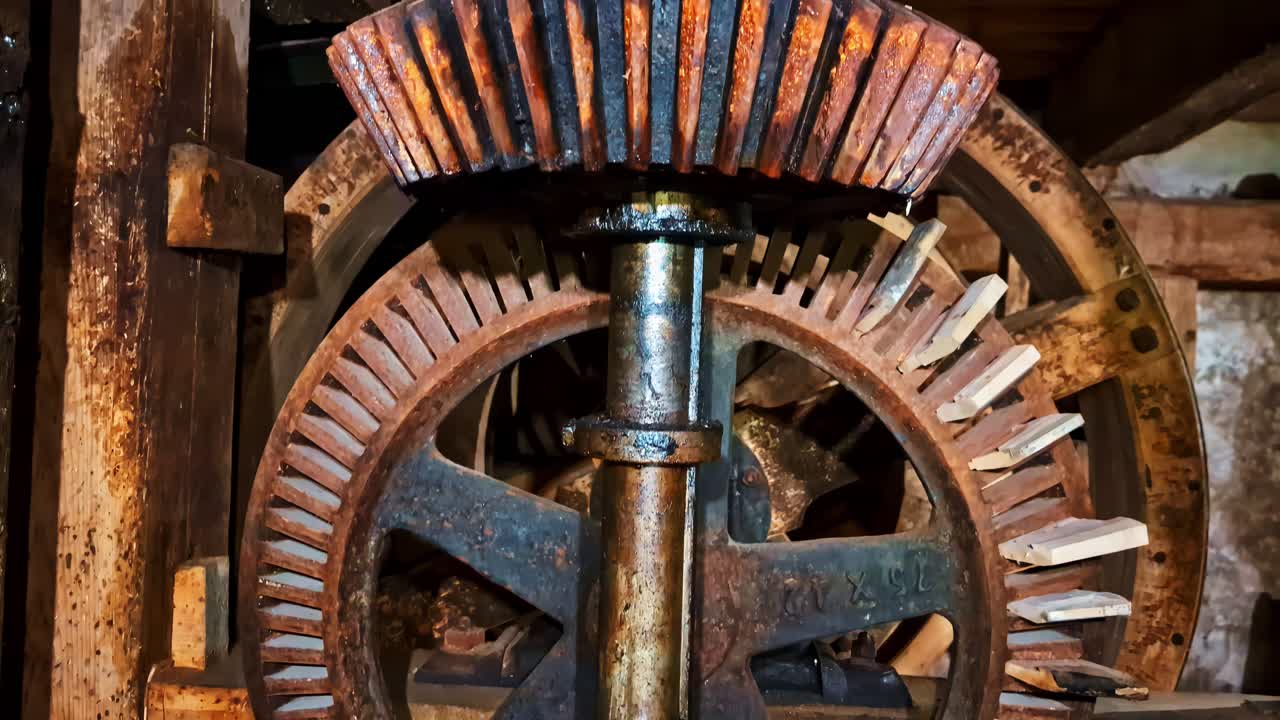 Starý a zrezivělý mechanický převodový systém starožitného mlýnského stroje v Jaunpils, Lotyšsko. Detailní záběr