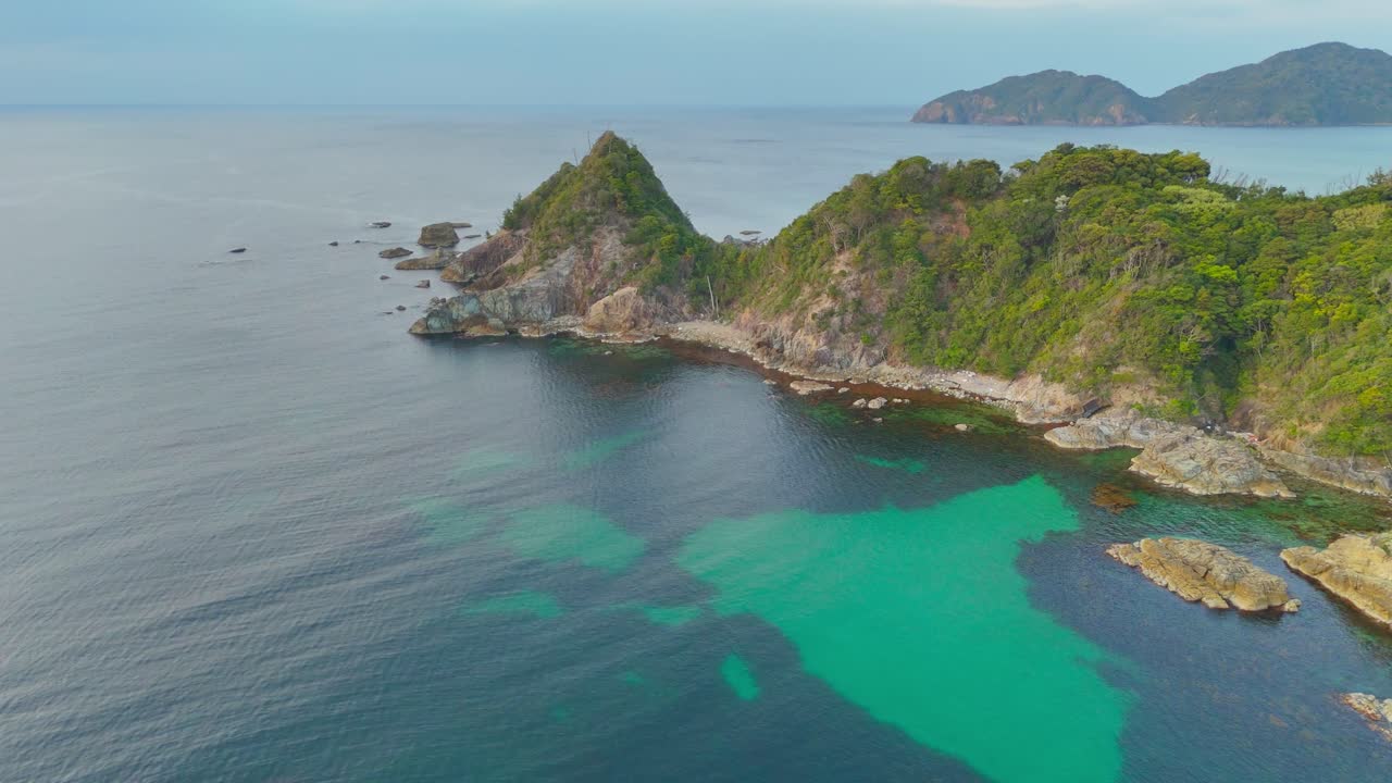Soar over the stunning Uradome Coast in Japan. This epic aerial shot reveals lush cliffs, clear turquoise waters, and the rugged beauty of the Coastline