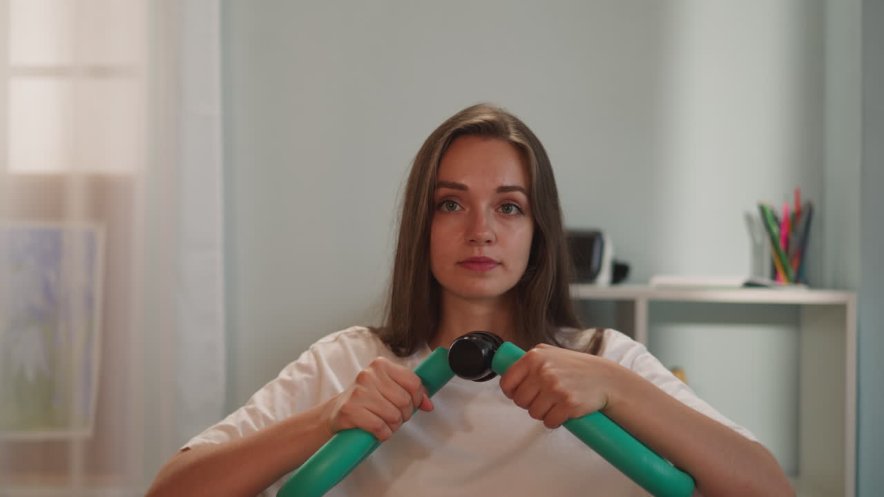 mujer joven usa aparatos de entrenamiento para estirar los músculos de los brazos