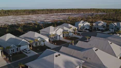 aerial of a residential subdivision and cleared forest nearby to build more homes