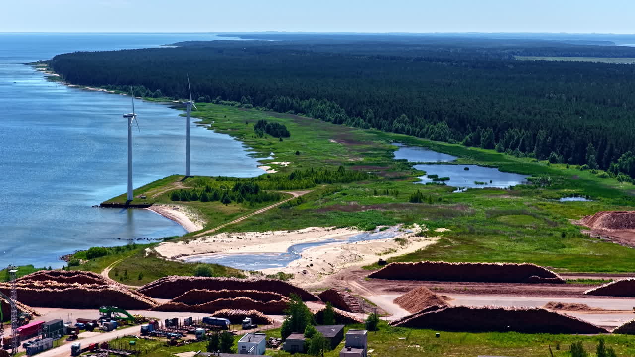 Windmills in a coastal maritime industrial area in Northern Europe. Aerial