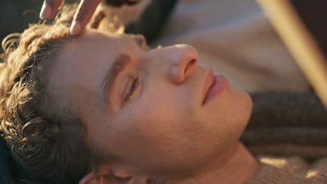woman hand stroking man head at warm sunlight closeup. boyfriend lying knees