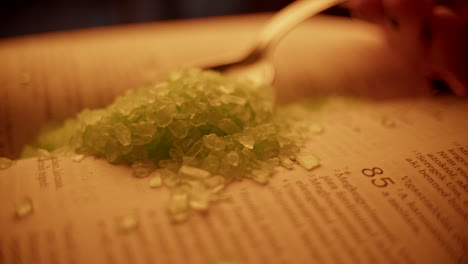 green salt on open book with spoon